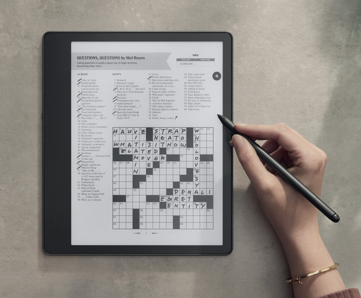 E-ink tablet displaying a crossword puzzle on a sunlit windowsill with a stylus